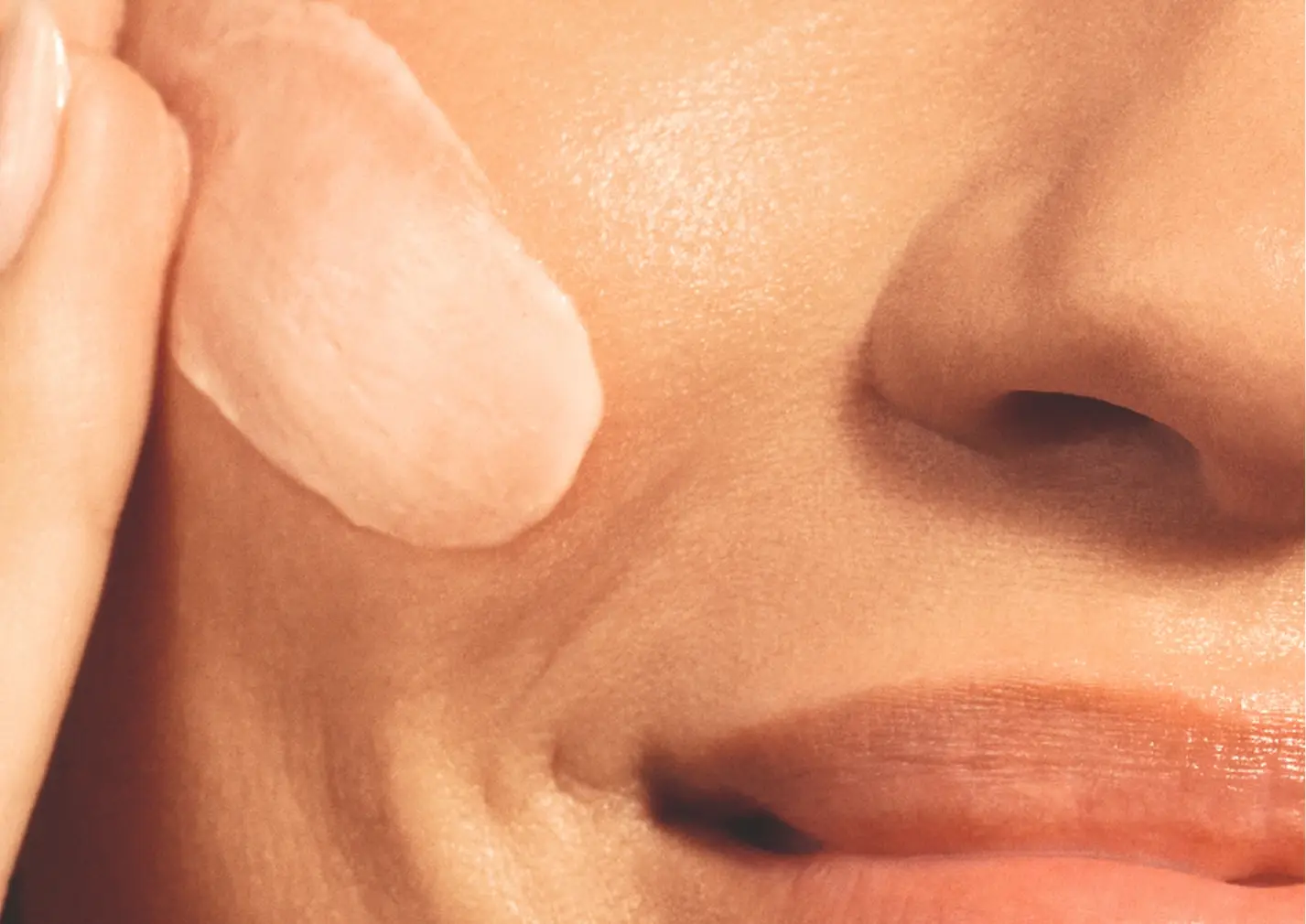 Femme qui étale de la crème sur son visage